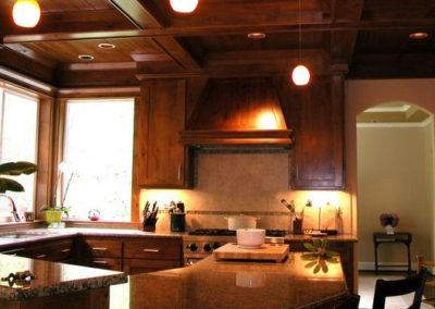 AFTER - Totally stripping the kitchen and adding knotty alder cabinetry, ceilings, and beams gave this kitchen the warmth it was missing.